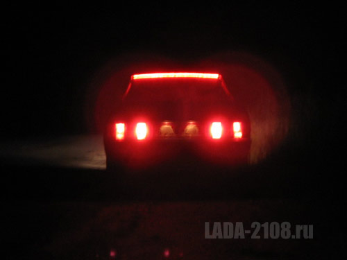 Вид на машину со включенными габаритными огнями и стоп-синалами в полной темноте